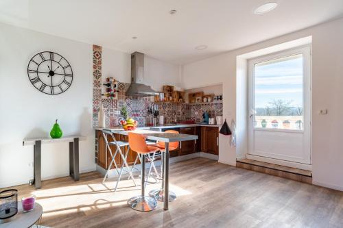 a kitchen with a table and chairs and a window at Gîte le Couderc in Gabriac
