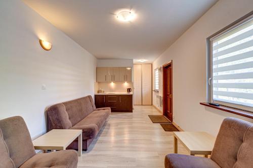 a living room with two couches and a kitchen at Pustkowo Domki Wakacyjne u Marka in Pustkowo