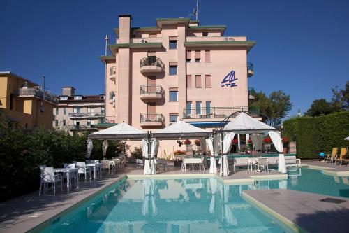 um hotel com piscina em frente a um edifício em Ute Hotel em Lido di Jesolo