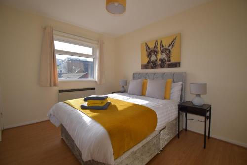 een slaapkamer met een bed met een gele deken erop bij Prime Location Apartment in Belfast