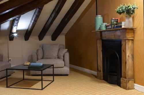 a living room with a chair and a fireplace at Petit Palace Preciados in Madrid