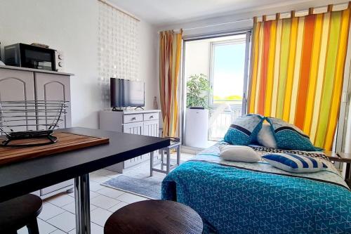 une chambre avec un lit, un bureau et une télévision dans l'établissement Studio Loggia Plage: 2 min à pied à Port-Argelès, à Argelès-sur-Mer