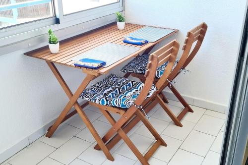 une table en bois et deux chaises dans l'établissement Studio Loggia Plage: 2 min à pied à Port-Argelès, à Argelès-sur-Mer
