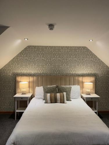 a bedroom with a large white bed with two tables at The Square Kintore in Kintore