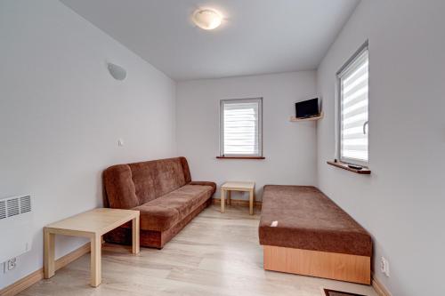 a living room with a couch and a table at Pustkowo Domki Wakacyjne u Marka in Pustkowo