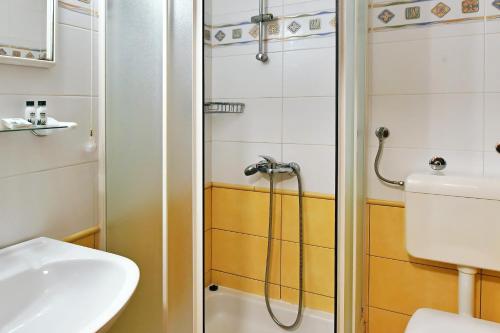 a bathroom with a shower and a toilet and a sink at Hotel Stanger in Lovran