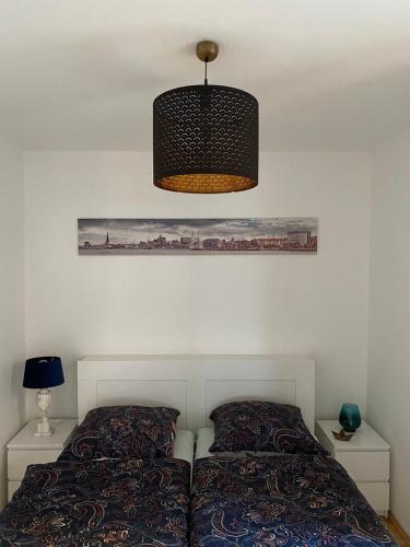 a bedroom with a bed and a hanging light at Hofquartier in Rostock