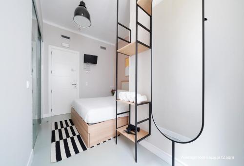 a small bedroom with a bed and a mirror at Numa Madrid Script in Madrid