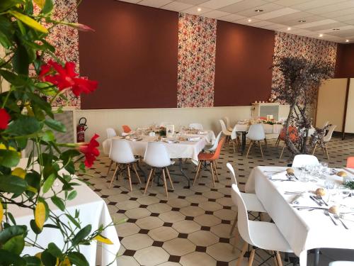 a dining room with white tables and chairs at Hôtel Aux Vendanges de Bourgogne in Paray-le-Monial