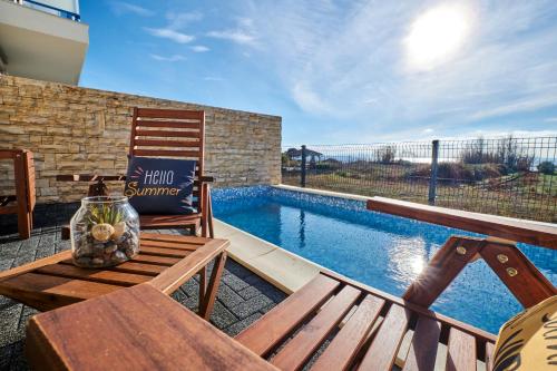 a patio with a bench and a swimming pool at Villa Miri II in Privlaka