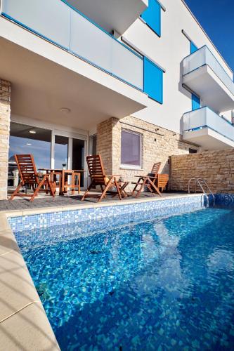 a swimming pool in front of a house at Villa Miri II in Privlaka