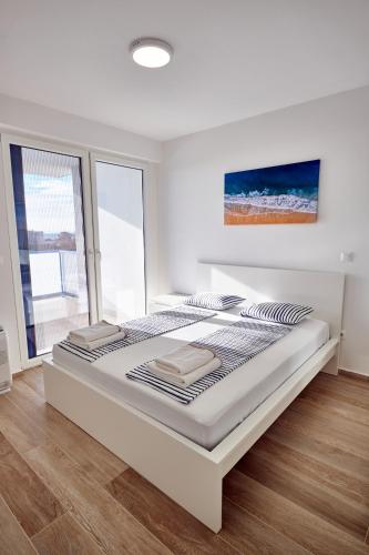 a white bedroom with a large bed in a room at Villa Miri II in Privlaka