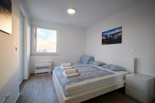 a bedroom with a bed in a room with a window at Villa Miri II in Privlaka
