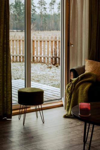 a living room with a couch and a window at Zielony domek nad Marychą w Budwieć in Stanowisko