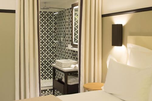 a hotel room with a bed and a bathroom at The Chess Hotel in Paris