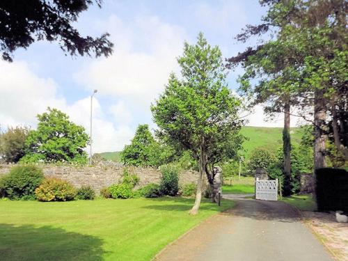 un parque con un árbol en medio de un campo en Leahurst Bed and Breakfast en Tywyn