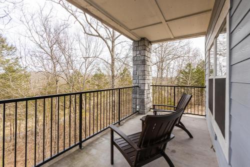 two chairs on a porch with a view of trees at Great Rock Resort at Branson in Branson