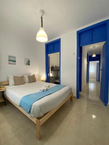 a bedroom with a large bed with blue doors at Amiais River Beach House in Amiães de Baixo