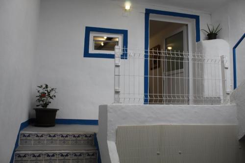 Habitación con paredes azules y blancas y puerta. en Amiais River Beach House, en Amiães de Baixo