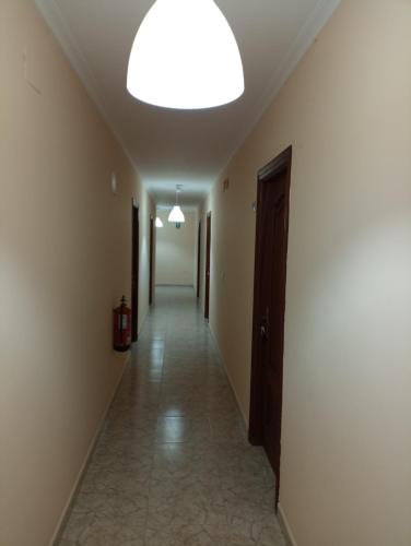an empty hallway with a large ceiling light and a hallway sidx sidx at O novo alto do couso in Ourense