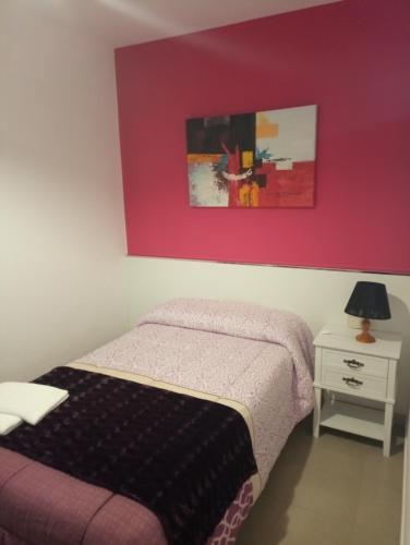 a bedroom with a bed and a red wall at O novo alto do couso in Ourense
