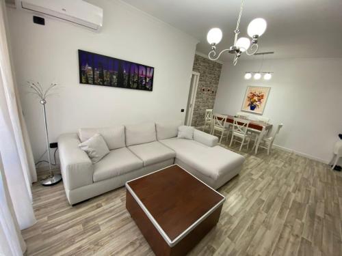 a living room with a white couch and a table at Tirana Center Apartment in Tirana