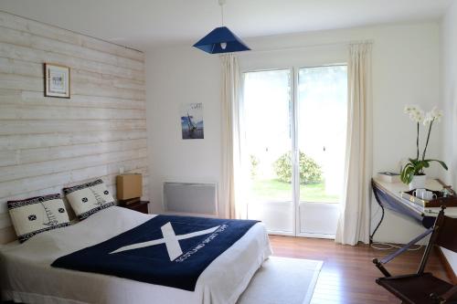 a bedroom with a bed and a desk and a window at Le Tertre Gatinais in Saint-Briac-sur-Mer