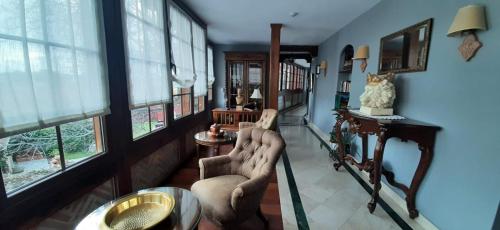 a living room with two chairs and windows at APARTAMENTOS TURÍSTICOS Y SUITES in Madrona