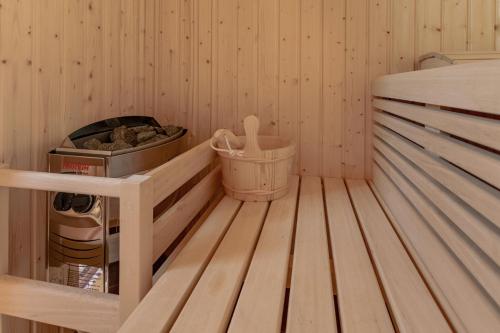 a wooden sauna with a trash can and a bucket at Kuća za odmor Rukova Hiža in Donja Stubica