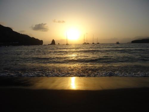 a sunset on the beach with boats in the water at Hotel Al Togo Fitness & Relax in Vulcano