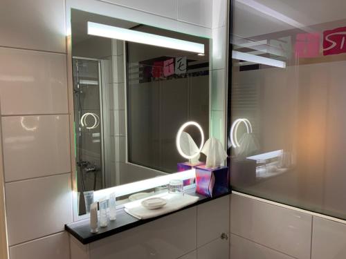 a bathroom with a sink and a mirror at RheinHotel ARTE in Remagen