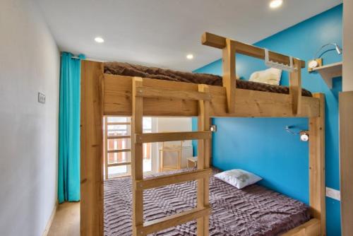 a bedroom with two bunk beds and a blue wall at Grand appartement 12 personnes au pied des pistes in Les Deux Alpes