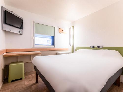 a bedroom with a white bed and a tv at ibis budget Bordeaux Centre Mériadeck in Bordeaux