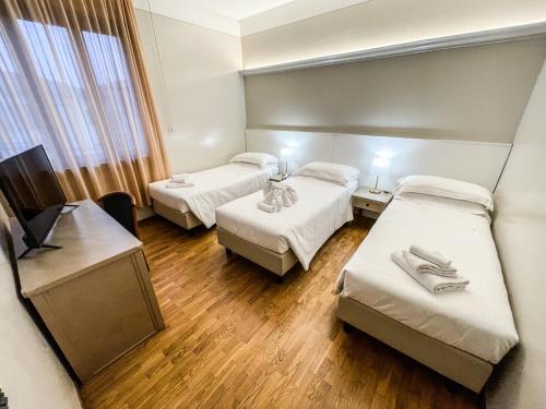 a hospital room with two beds and a television at Hotel Elefante in Montichiari