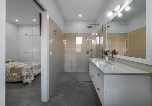 La salle de bains est pourvue d'un lavabo, d'une douche et d'un lit. dans l'établissement Villa Son Blanc Grupo Seranova Luxury Hotel, à Sa Caleta