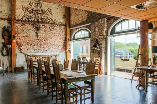 a dining room with a wooden table and chairs at 't Brouwershuis in Leende