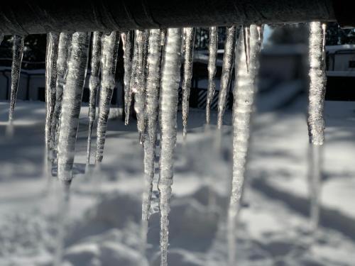 a bunch of icicles hanging from a building in the snow at Hotel a Penzion PEGAS in Nové Město na Moravě