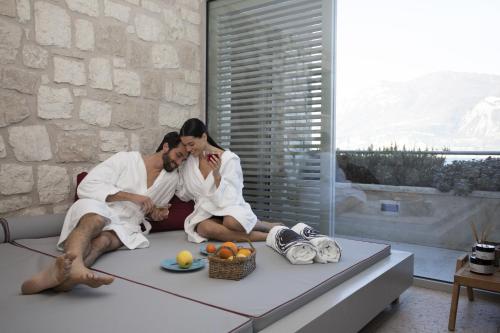 a couple sitting on a couch in a living room at Sunset Residence in Brenzone sul Garda