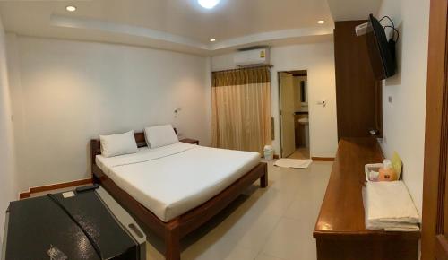 a bedroom with a bed and a television in it at SB Mansion in Buriram