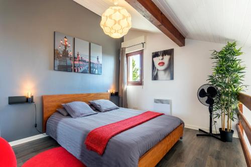 a bedroom with a bed with a red blanket at DUPLEX DESIGN TERRASSE - Parking in Mont-de-Marsan