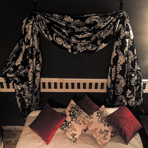 a black and white curtain over a bed with pillows at Athenea Villas, Private Pools & Gardens in Keri