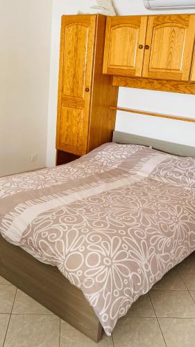 Ce lit se trouve dans une chambre dotée d'une armoire en bois. dans l'établissement Vue mer panoramique et piscine, à Bandol