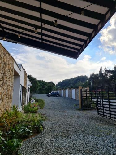 a barn with a car parked in a driveway at Casa Hotel Bremen in Circasia