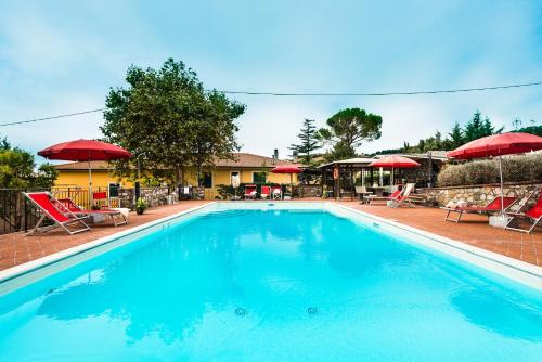 a large swimming pool with chairs and umbrellas at Agriturismo La Ghiraia in Santa Luce