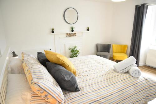 a bedroom with a bed with pillows and a mirror at Lower Flat Hillhouse in Portree
