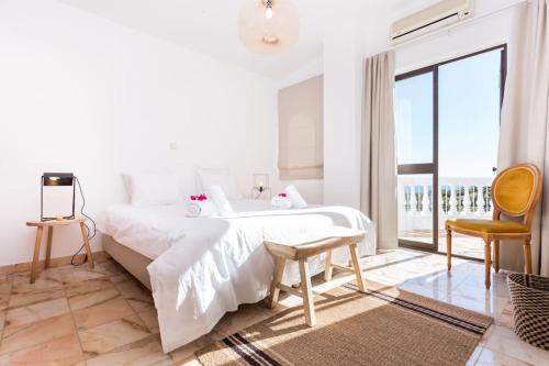 una camera da letto bianca con un letto e un balcone di Ocean view beach villa a Budens
