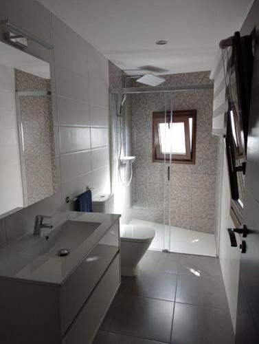 a bathroom with a tub and a toilet and a sink at Casa Alberto in A Guarda