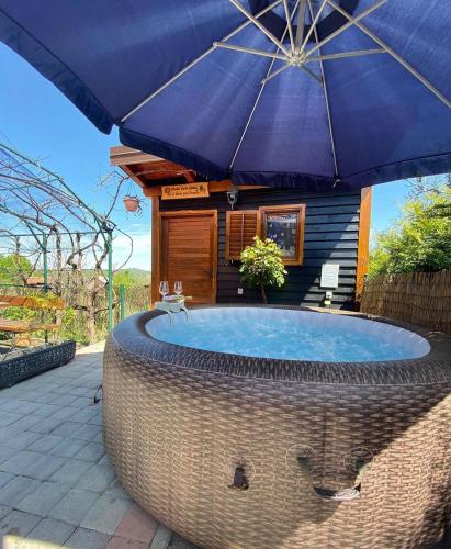 a hot tub with an umbrella on a patio at Kuća za odmor Rukova Hiža in Donja Stubica