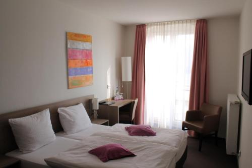 a hotel room with a bed with two pillows on it at RheinHotel ARTE in Remagen