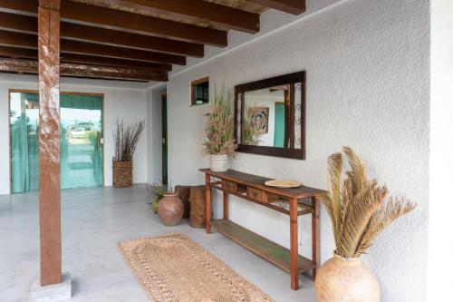 a room with a table and a mirror on a wall at Tropical Beach in Porto Seguro